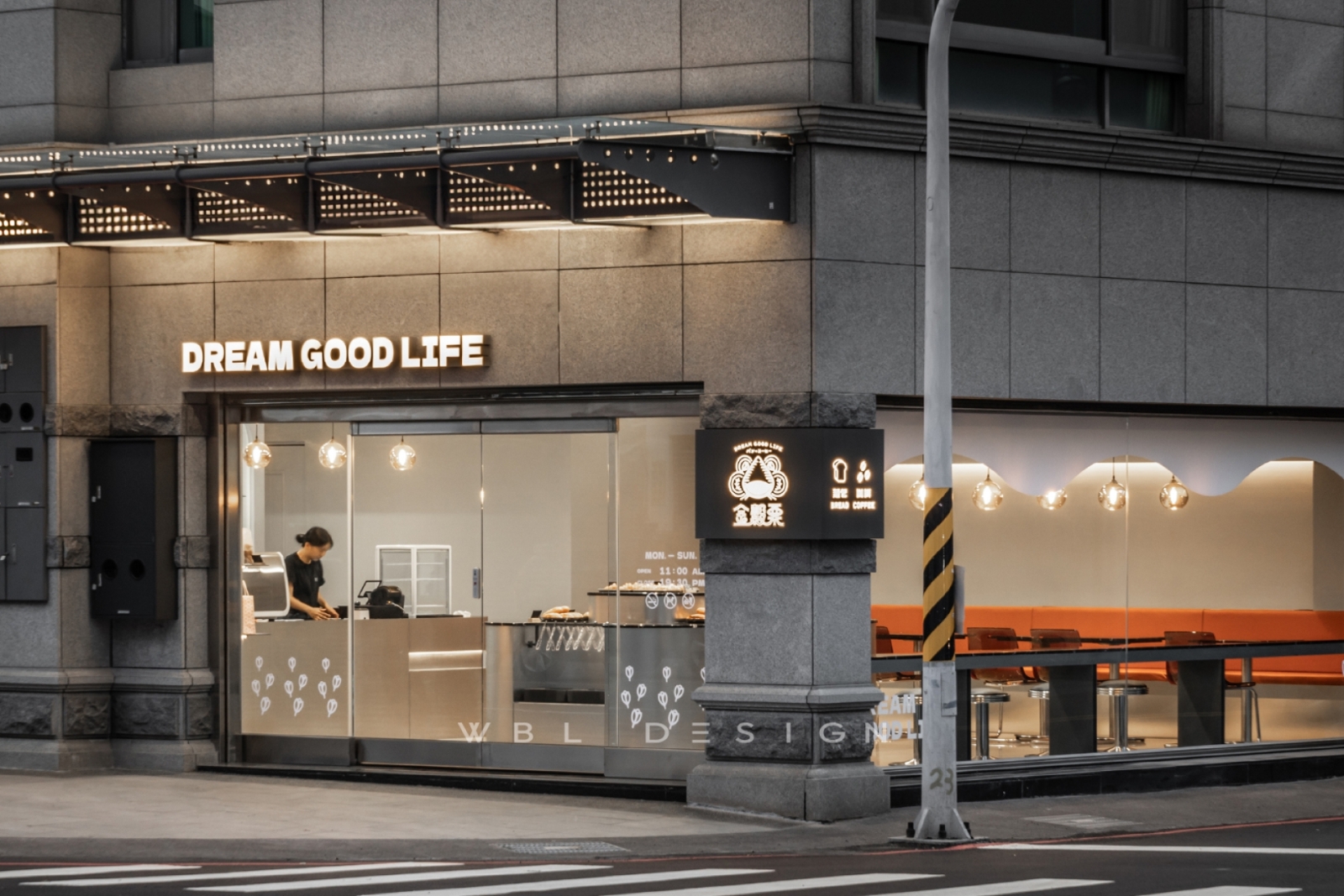 商業空間設計案例,街角烘焙店採用玻璃門面、發光招牌與橘色座位區